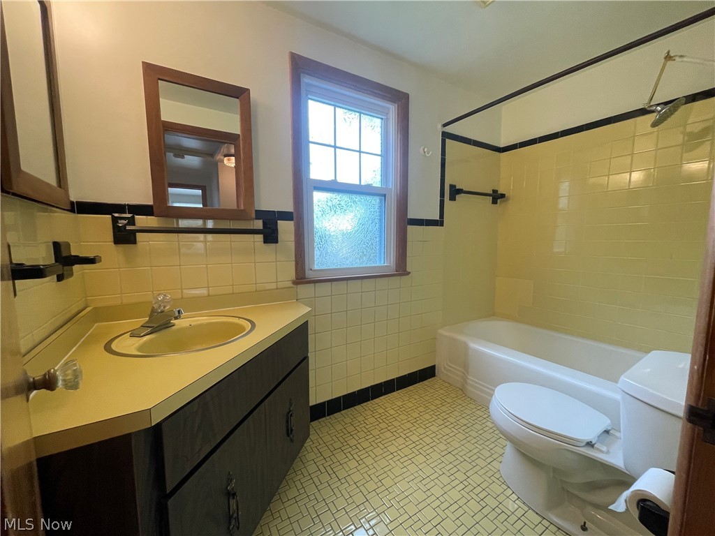 1508 Edgefield Road Lyndhurst, OH 44124 - Photo 13 of 28 Full bathroom featuring tiled shower / bath, tile walls, tasteful backsplash, vanity, and toilet