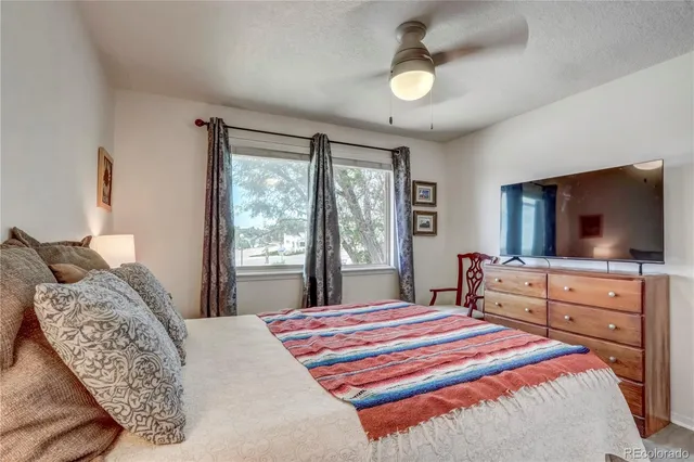 a bedroom with a large bed and a flat tv screen on dresser