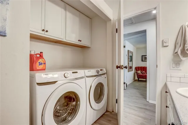 a view of washer and dryer with bathroom in the background