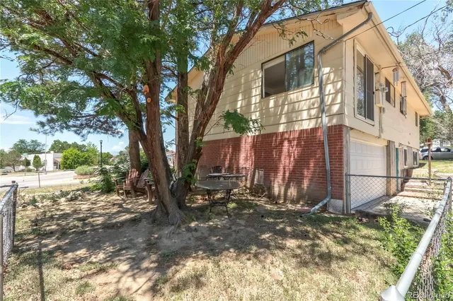 a view of a house with backyard and trees