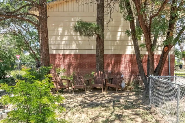 a view of backyard with a table and chairs and iron fence