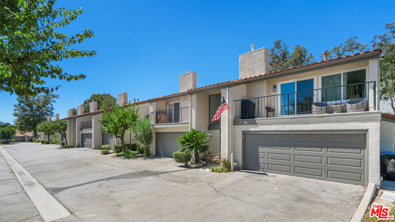 19547 Rinaldi Street, Unit 30 Porter Ranch, CA 91326 - Photo 30 of 33 a view of a house with a yard and potted plants