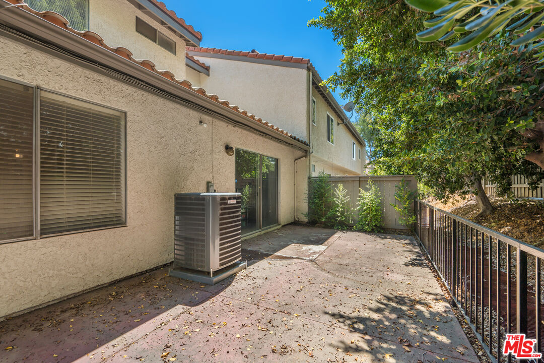 19547 Rinaldi Street, Unit 30 Porter Ranch, CA 91326 - Photo 7 of 33 a view of a backyard with wooden fence and large trees