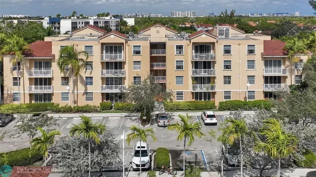 a view of a white building among the street and plants