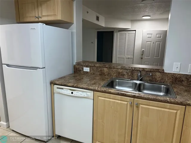 a close view of a sink and a refrigerator in a kitchen