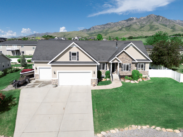 580 Cherry Ridge Lane Richmond, UT 84333 - Photo 50 of 53 Craftsman-style house featuring stone siding, a mountain view, driveway, roof with shingles, and an attached garage