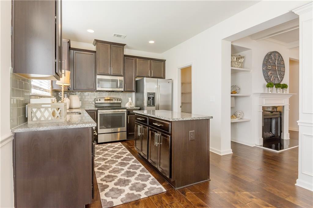 5811 Radford Loop, Unit 333 Fairburn, GA 30213 - Photo 1 of 1 a kitchen with stainless steel appliances granite countertop a refrigerator a stove top oven a sink and dishwasher