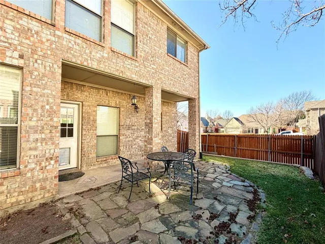 a view of a patio with table and chairs near a yard