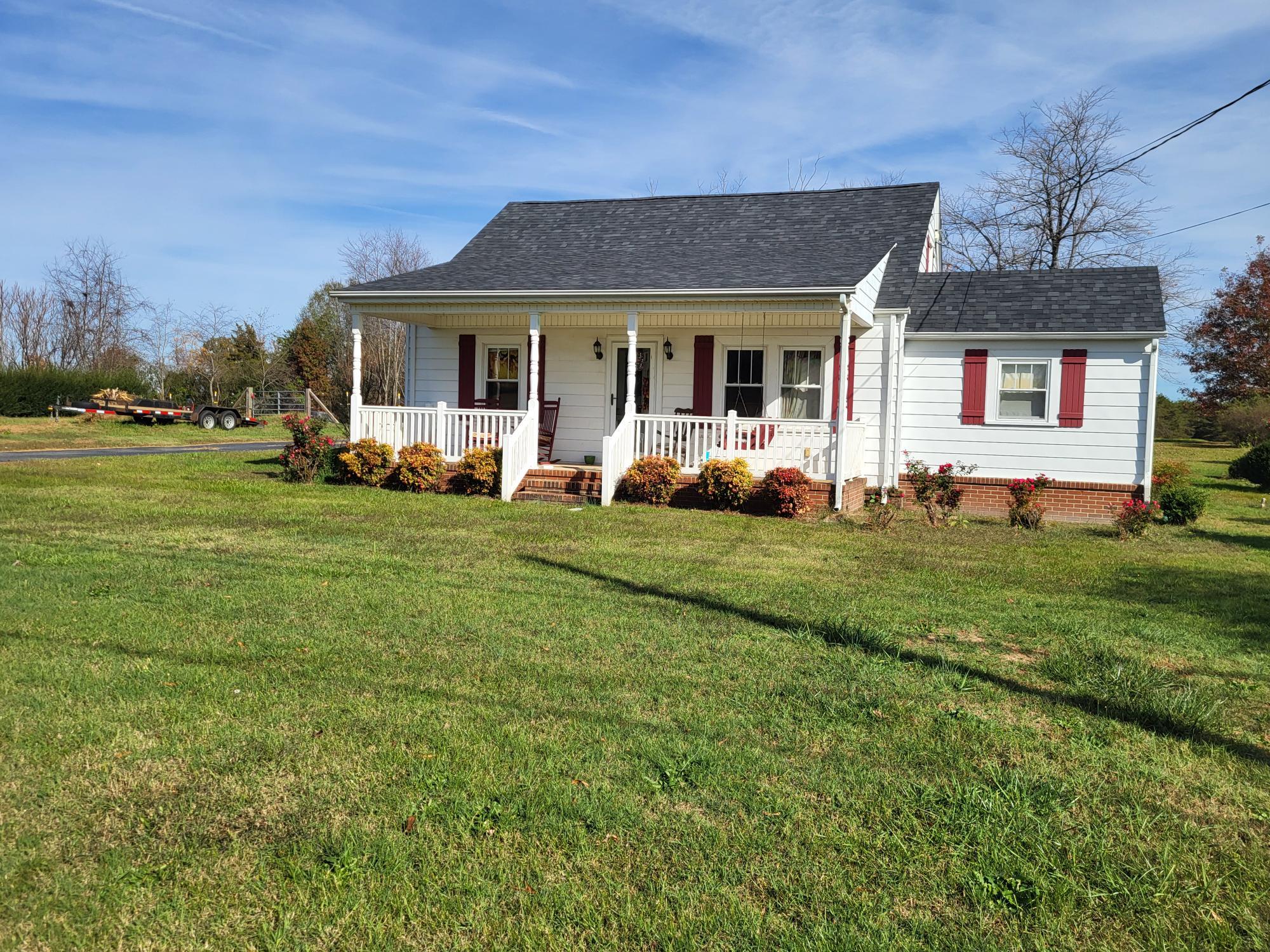 1081 East Gretna Road Gretna, VA 24557 - Photo 2 of 40 a front view of a house with a garden and porch