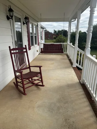 a view of a porch with furniture and a gate