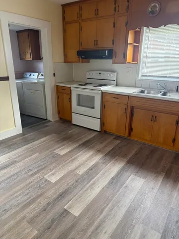 a kitchen with a sink cabinets and wooden floor