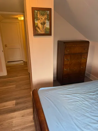 a bedroom with a bed and a painting on the wall