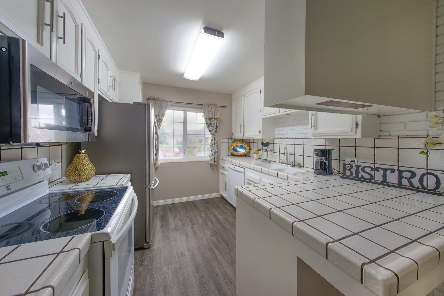 2952 Tahoe Drive Merced, CA 95340 - Photo 18 of 70 kitchen with tile countertops, stainless steel appliances, and white cabinetry