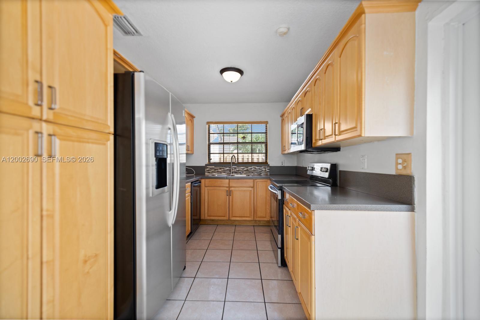 10726 Southwest 147th Court Miami, FL 33196 - Photo 14 of 23 a kitchen with stainless steel appliances granite countertop a refrigerator and a stove top oven