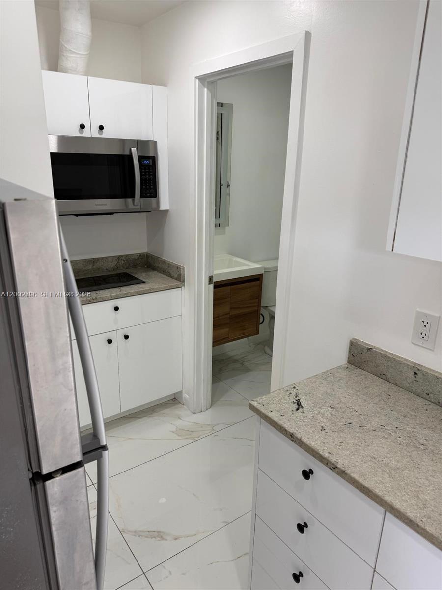 10726 Southwest 147th Court Miami, FL 33196 - Photo 23 of 23 a kitchen with granite countertop a sink and a stove