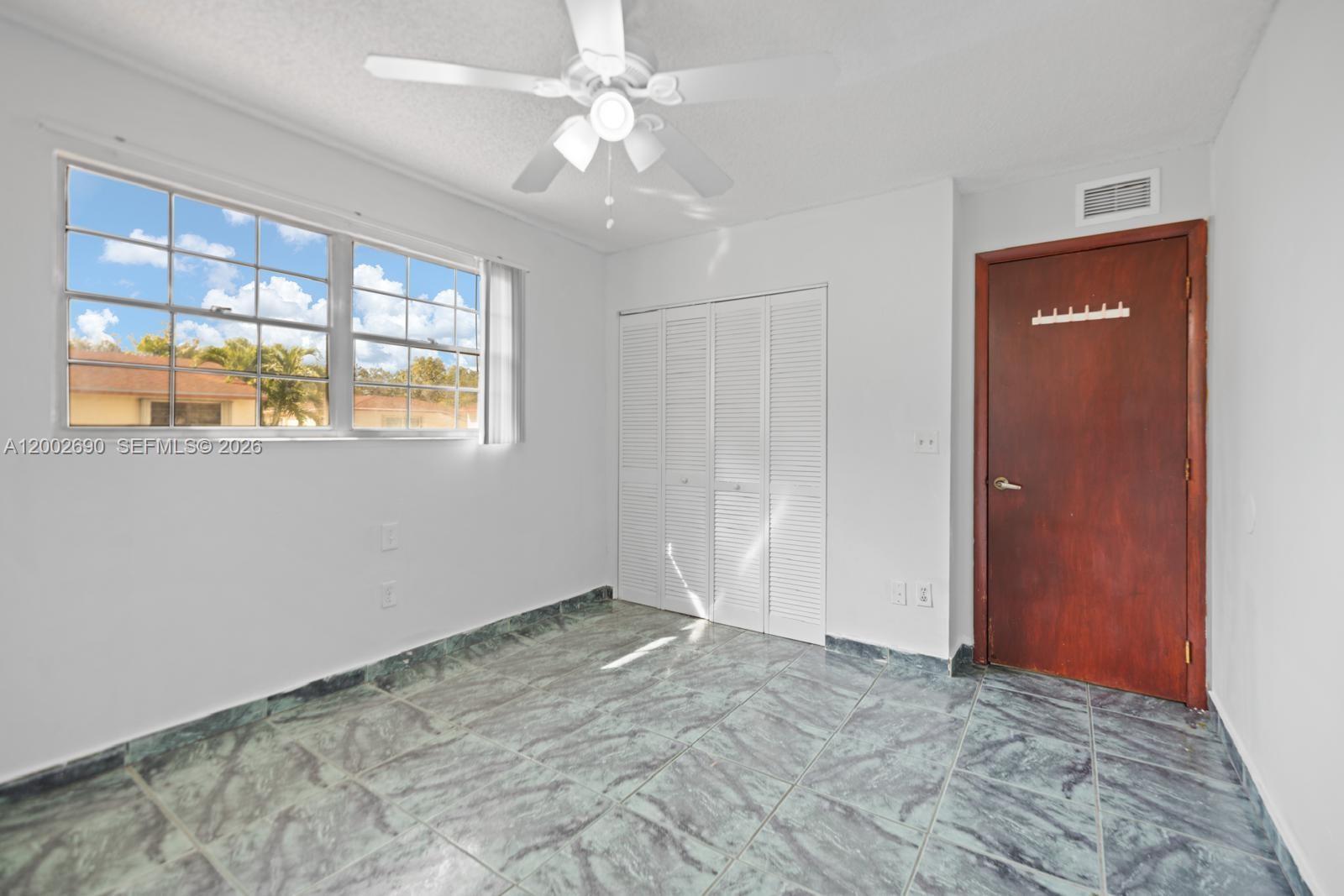 10726 Southwest 147th Court Miami, FL 33196 - Photo 7 of 23 a view of an empty room with a window