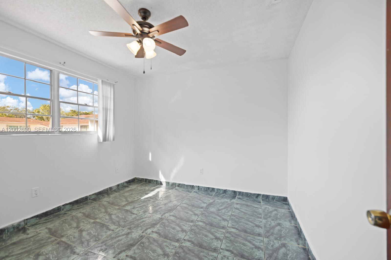 10726 Southwest 147th Court Miami, FL 33196 - Photo 8 of 23 an empty room with windows and fan