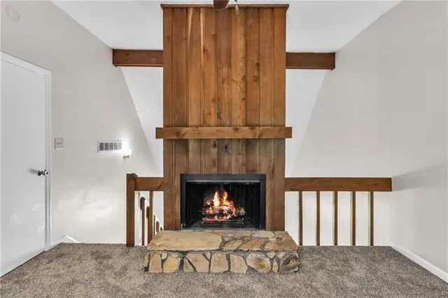 a view of an empty room with fireplace and a window