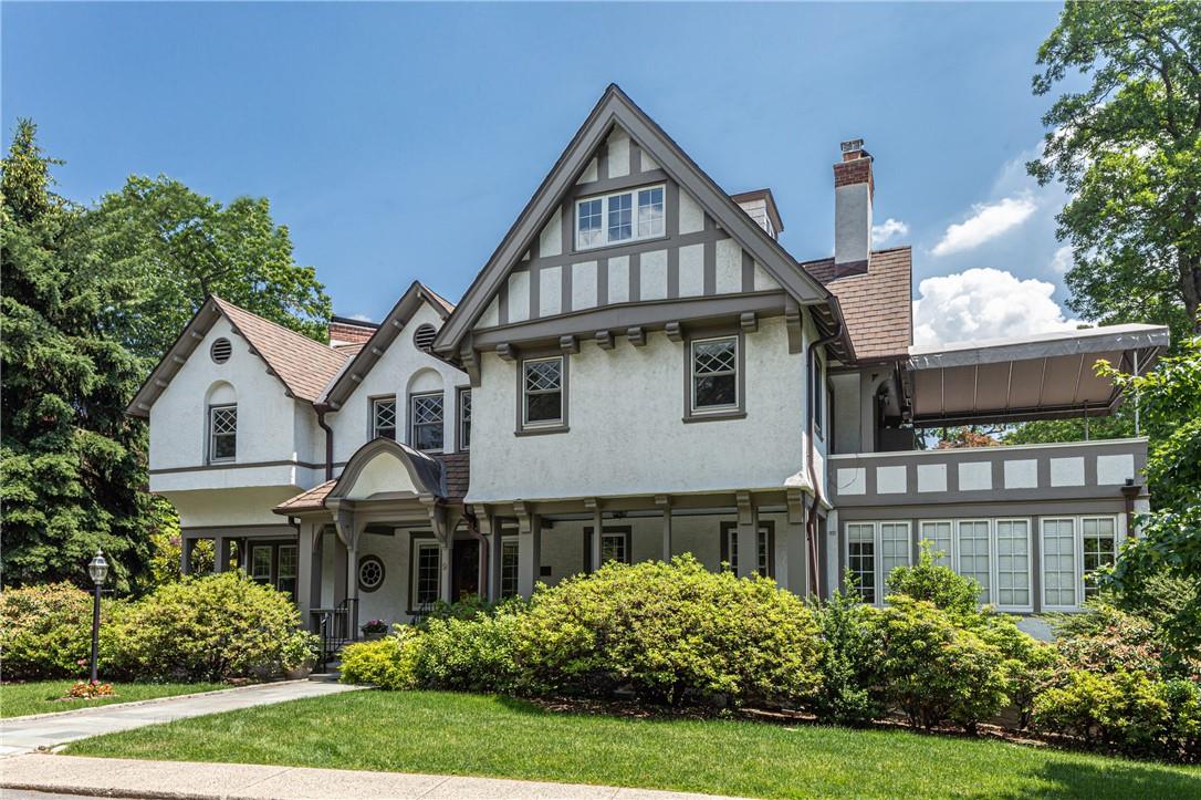 a front view of a house with a yard and trees