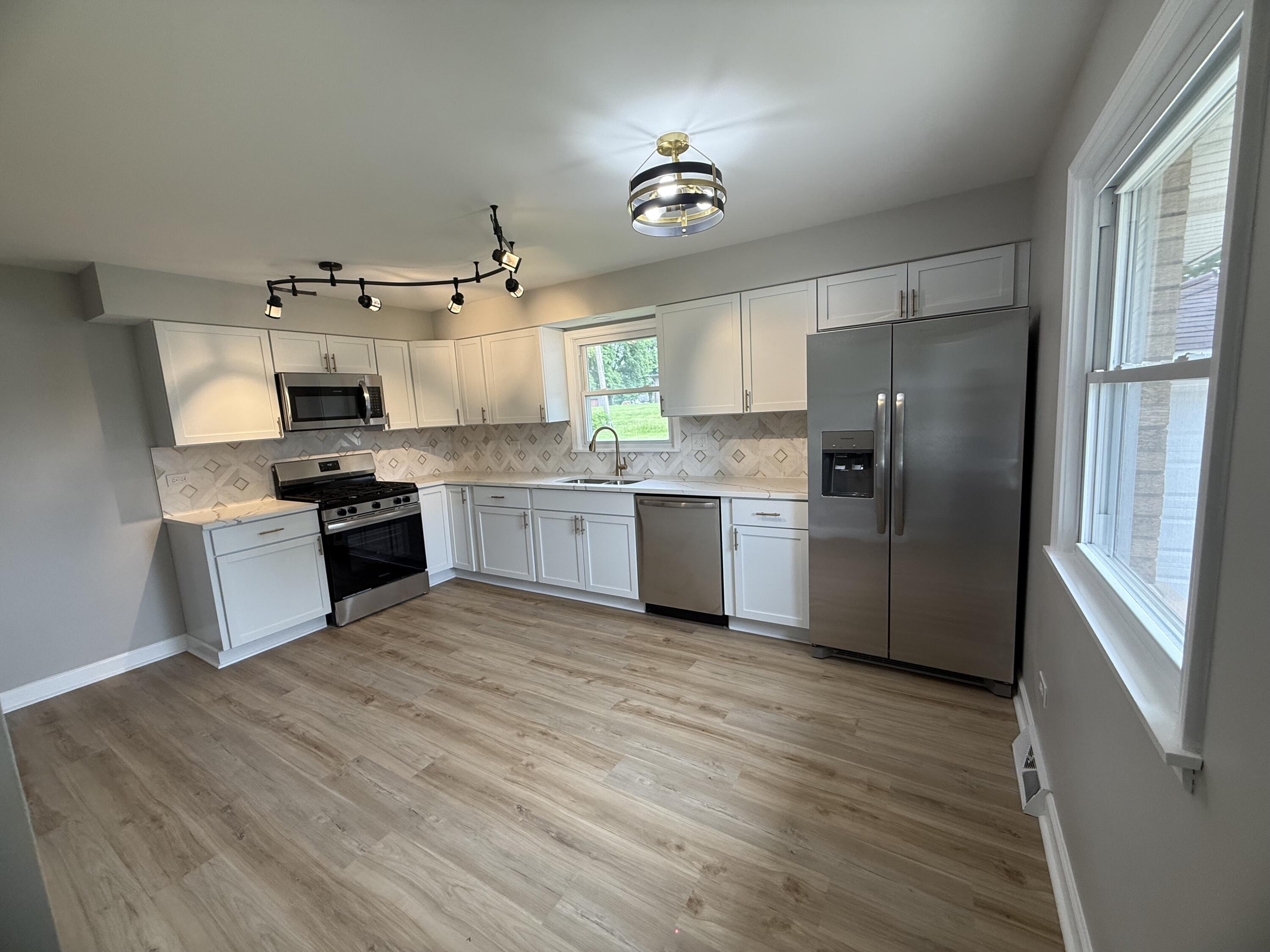 408 Cherry Hill Road Dyer, IN 46311 - Photo 11 of 31 a kitchen with stainless steel appliances granite countertop a stove top oven a refrigerator a sink and dishwasher with wooden floor