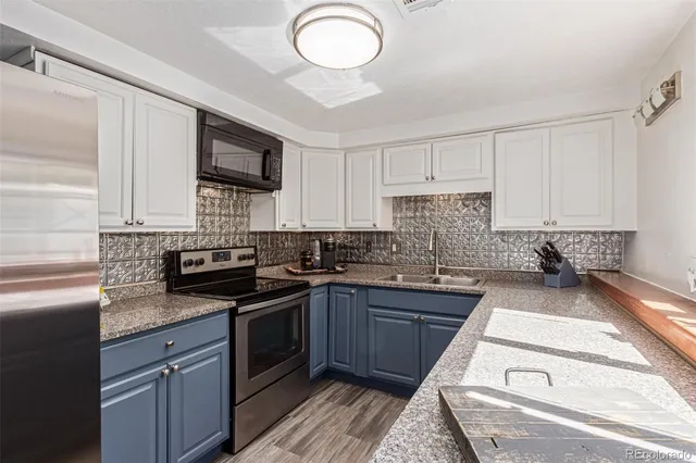 a kitchen with a sink stove top oven and microwave