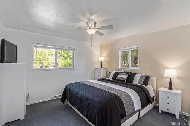 a bedroom with a bed and a flat tv screen on dresser