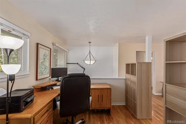 a view of a workspace with furniture and a window