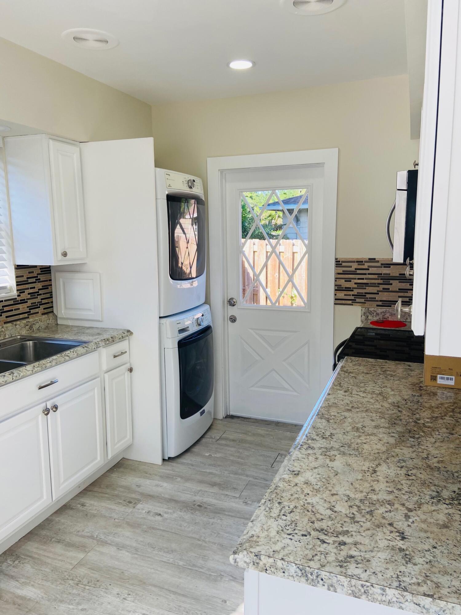 615 Northeast 2nd Avenue Delray Beach, FL 33444 - Photo 11 of 35 a kitchen with stainless steel appliances granite countertop a stove a sink and a refrigerator
