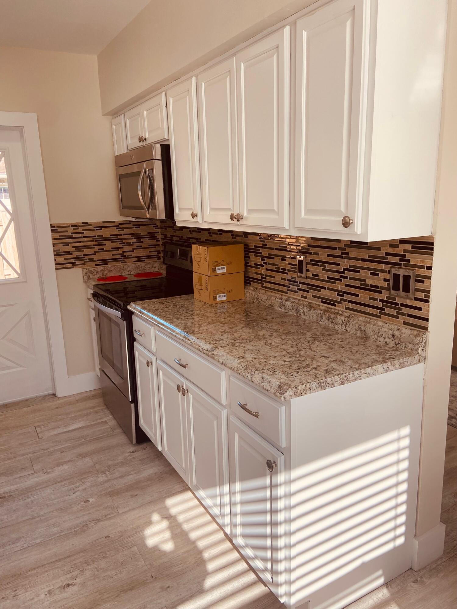 615 Northeast 2nd Avenue Delray Beach, FL 33444 - Photo 12 of 35 a kitchen with granite countertop a stove sink and cabinets