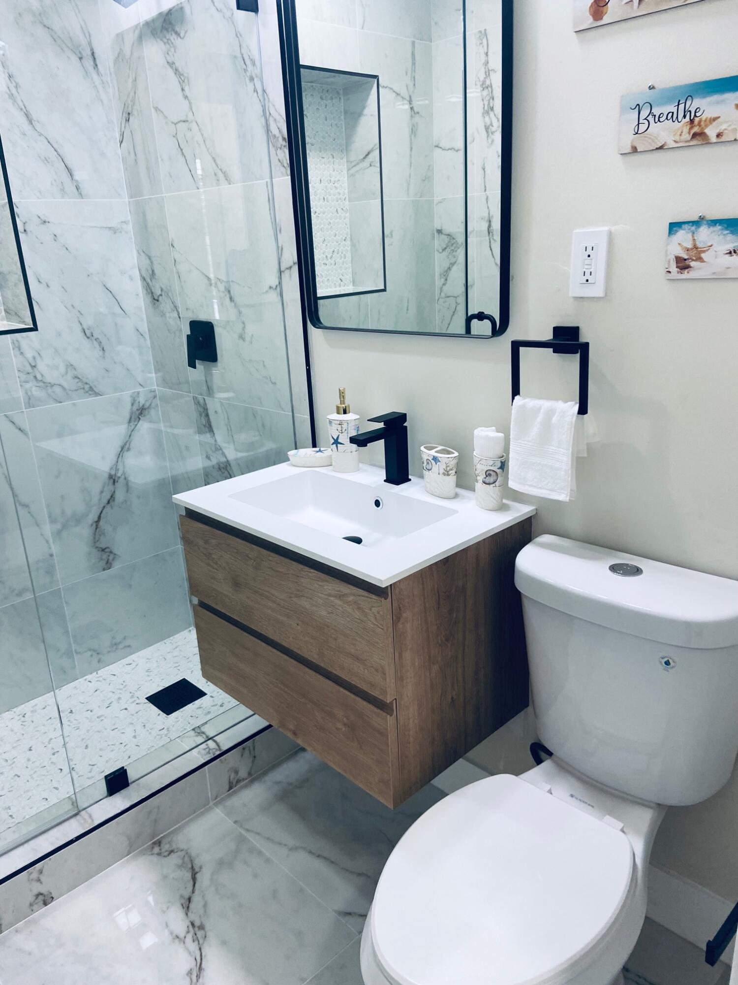 615 Northeast 2nd Avenue Delray Beach, FL 33444 - Photo 21 of 35 a bathroom with a sink a toilet and mirror