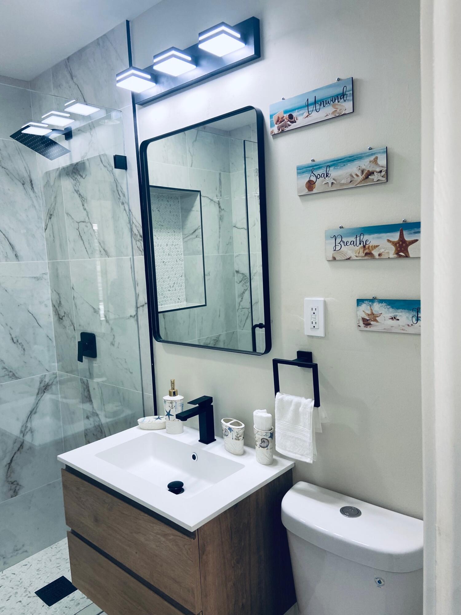 615 Northeast 2nd Avenue Delray Beach, FL 33444 - Photo 22 of 35 a bathroom with a sink a toilet and a mirror