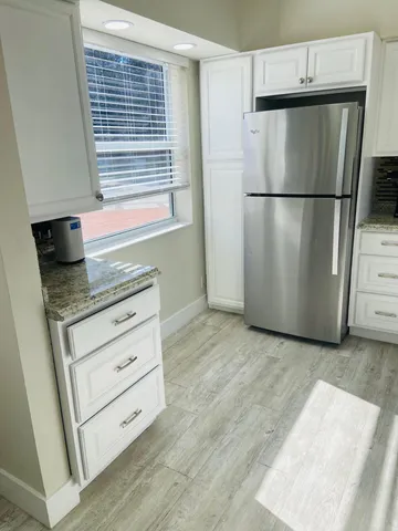 a kitchen with granite countertop a stove sink and cabinets