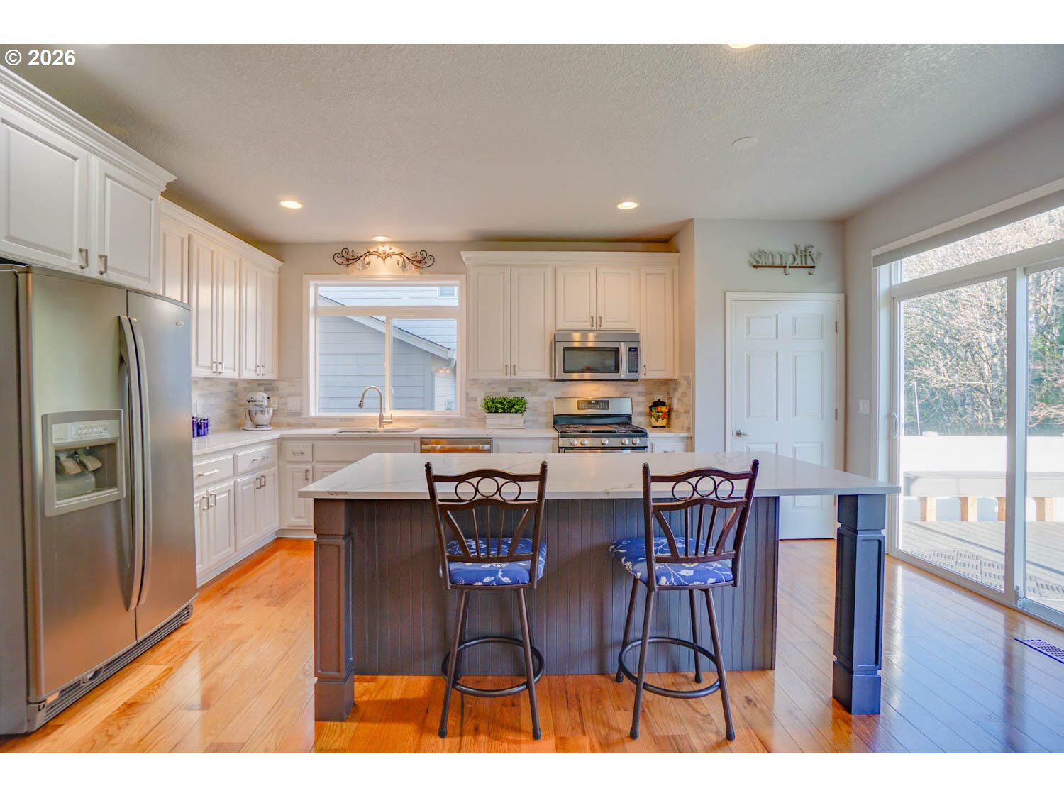 1612 North Heron Drive Ridgefield, WA 98642 - Photo 6 of 33 a kitchen with stainless steel appliances a dining table chairs refrigerator and sink