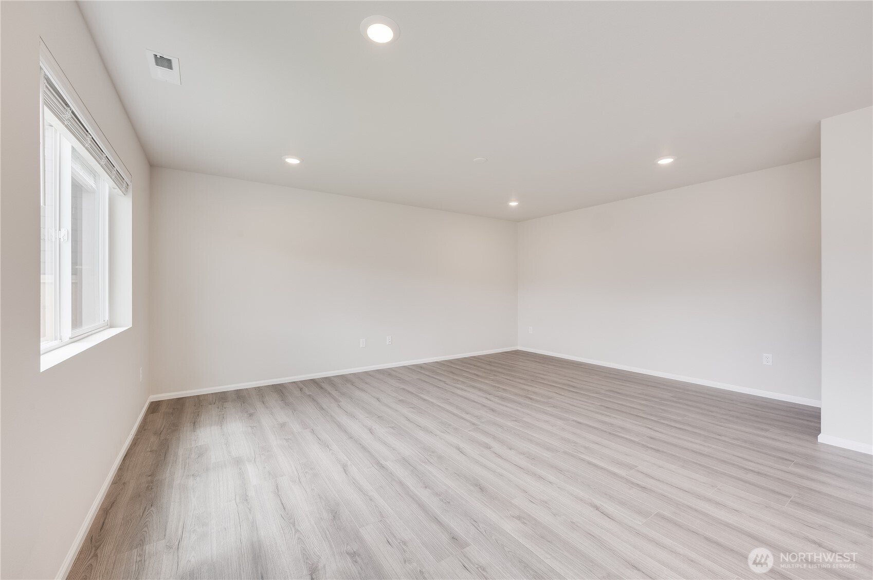 1012 15th Avenue Sultan, WA 98294 - Photo 7 of 26 an empty room with wooden floor and windows
