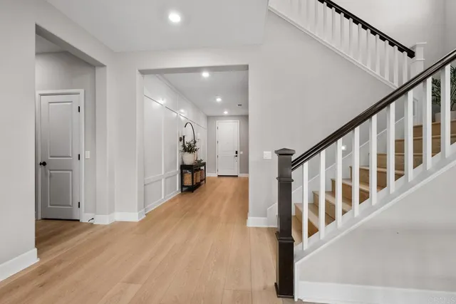 a view of a hallway with wooden floor and staircase