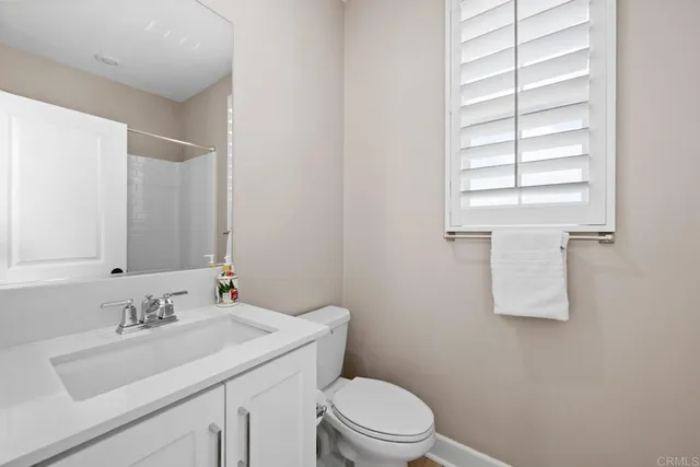 a bathroom with a sink toilet vanity and a window