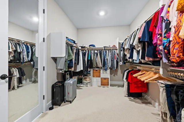 a view of walk in closet with clothes and shoes