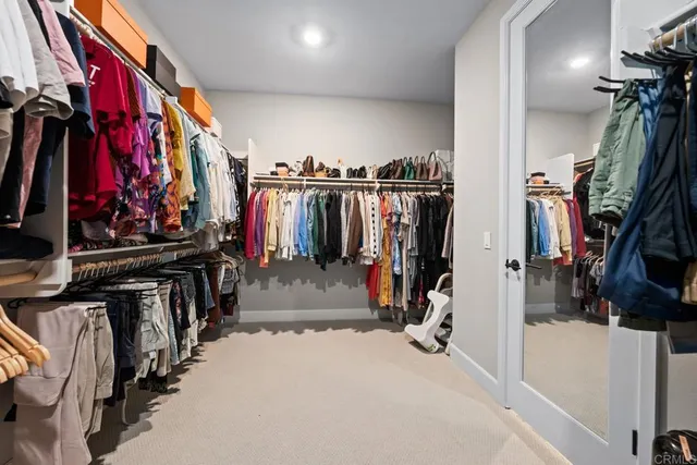 a view of walk in closet with clothes