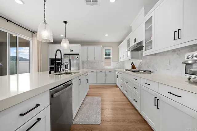 a large kitchen with cabinets and wooden floors
