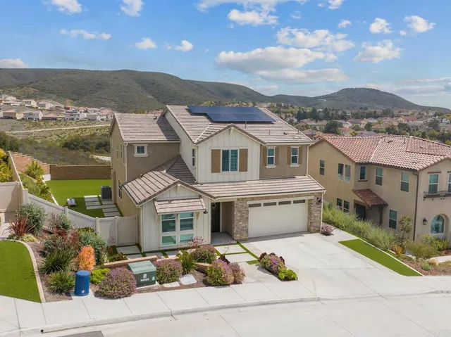 a front view of a house with a garden and balcony