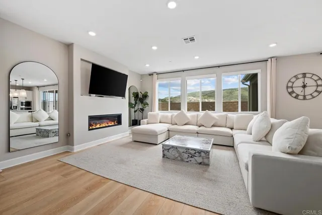 a living room with furniture a fireplace and a flat screen tv