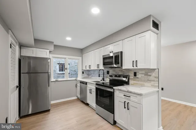 a kitchen with stainless steel appliances granite countertop a refrigerator a stove top oven a sink and dishwasher