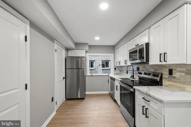 a kitchen with stainless steel appliances a stove a sink and a microwave