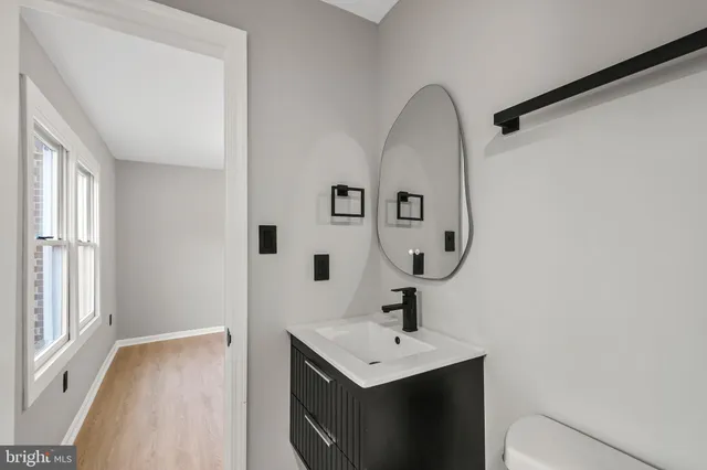 an empty room with wooden floor and ceiling fan