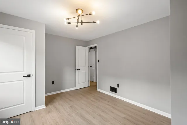 a view of empty room with windows and chandelier fan