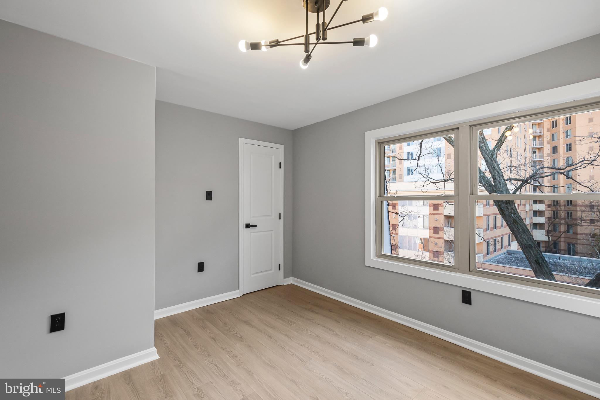 1527 North Colonial Terrace, Unit B Arlington, VA 22209 - Photo 25 of 28 a view of empty room with windows and chandelier fan