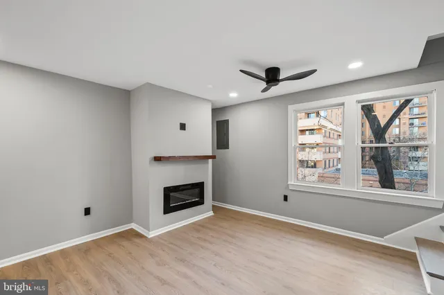 a view of an empty room with a fireplace and a window