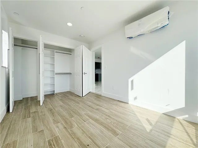 a view of an empty room with closet and a window