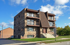 8800 West 76th Place, Unit 2W Justice, IL 60458 - Photo 1 of 8 a front view of a residential apartment building with a yard