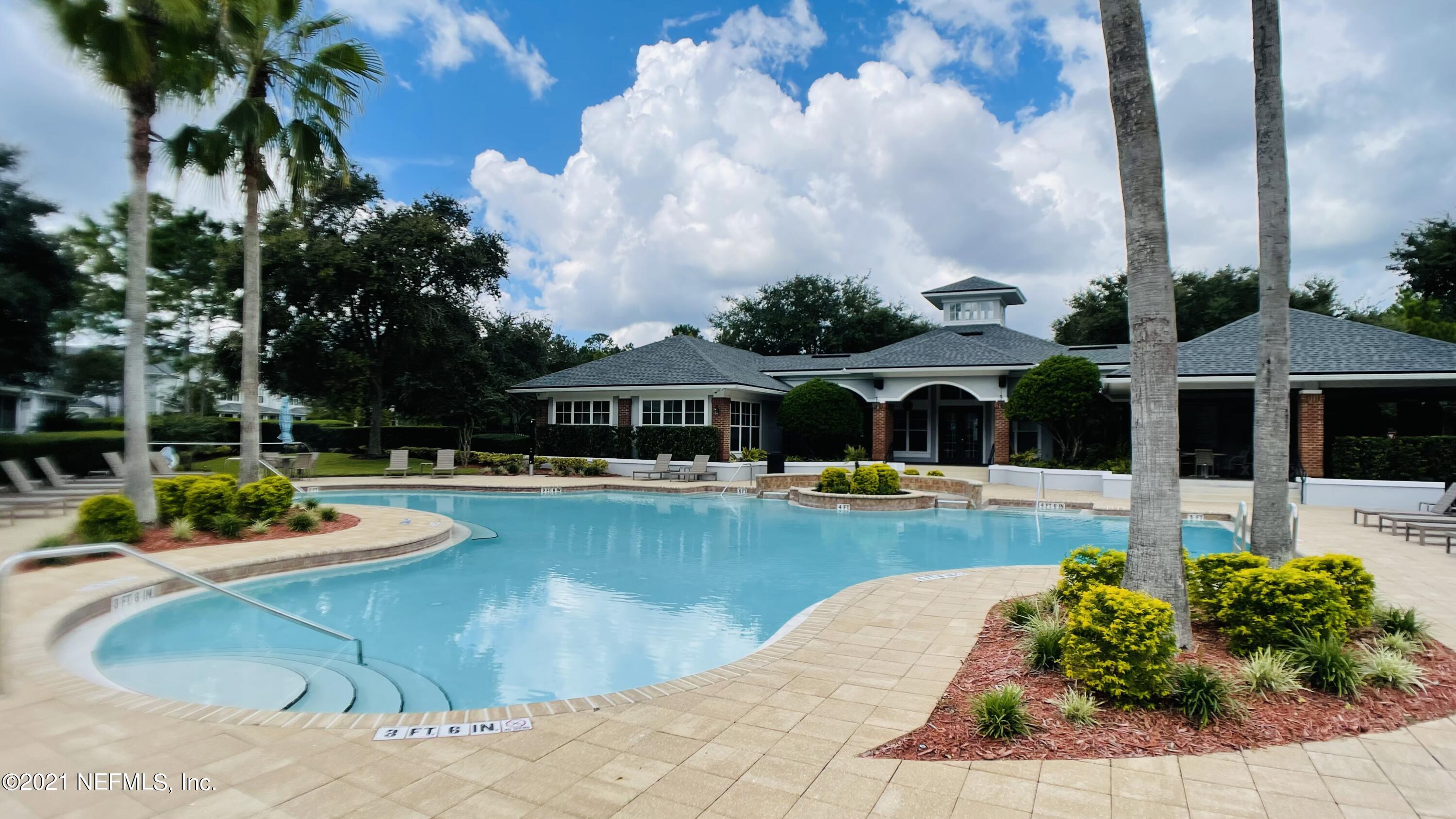 3586 Pebble Path Lane Jacksonville, FL 32224 - Photo 19 of 21 a view of a swimming pool with a table and chairs under an umbrella
